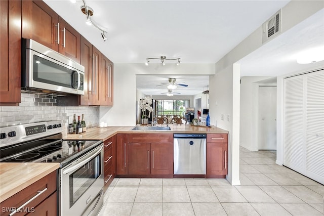 kitchen featuring ceiling fan, light tile patterned floors, sink, and stainless steel appliances