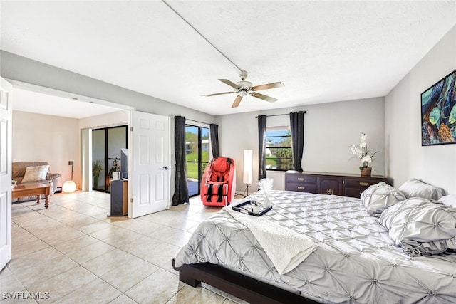 bedroom featuring light tile patterned floors, ceiling fan, access to exterior, and a textured ceiling