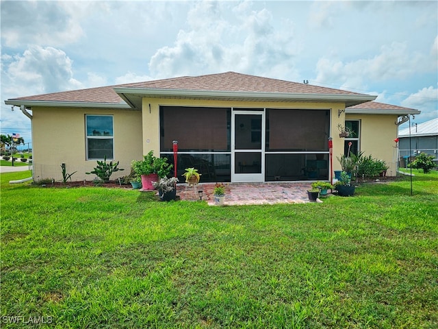 rear view of property with a sunroom and a yard