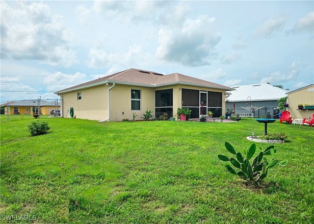 back of house with a yard and a sunroom