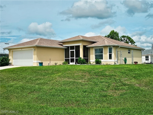 view of front facade featuring a garage, a sunroom, and a front lawn