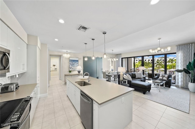 kitchen featuring pendant lighting, a center island with sink, white cabinets, sink, and stainless steel appliances