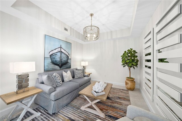 living room with a notable chandelier and a tray ceiling