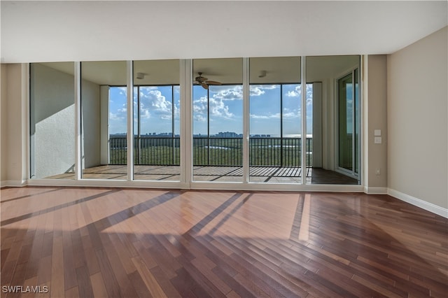 spare room with hardwood / wood-style flooring and a wall of windows