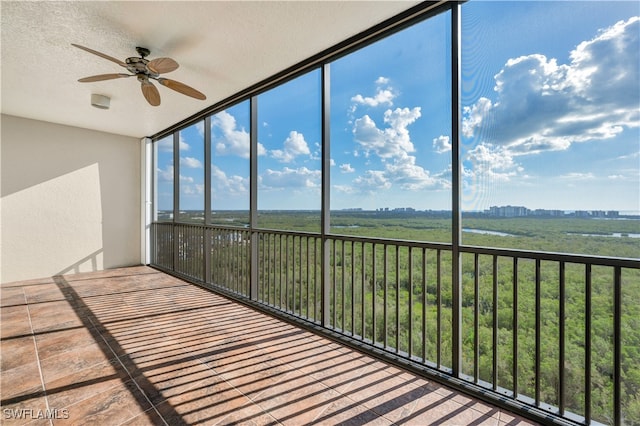 unfurnished sunroom featuring a wealth of natural light and ceiling fan