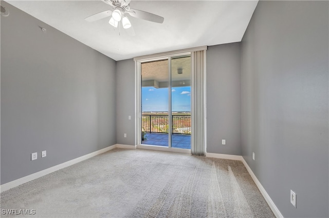 spare room with ceiling fan and light carpet