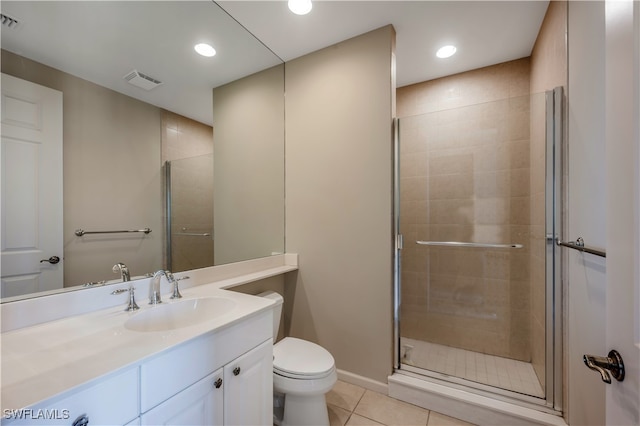 bathroom with tile patterned floors, a shower with door, vanity, and toilet