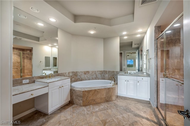 bathroom featuring vanity, a tray ceiling, and separate shower and tub