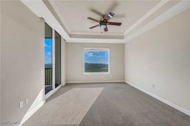 spare room with a raised ceiling, crown molding, ceiling fan, and light carpet