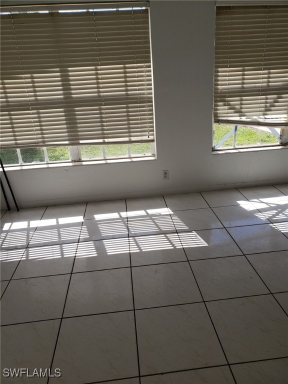 tiled spare room featuring a wealth of natural light