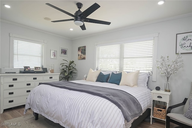 bedroom featuring dark hardwood / wood-style flooring, crown molding, and ceiling fan