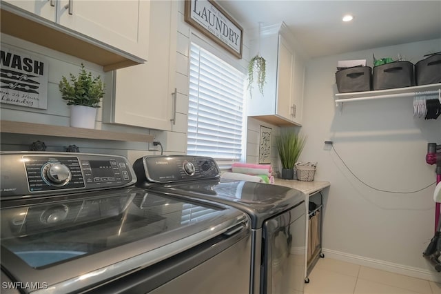 laundry room featuring light tile patterned flooring, cabinets, and separate washer and dryer