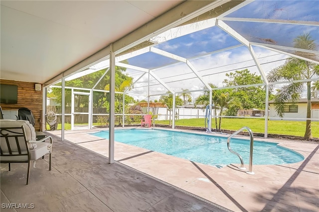 view of pool with a yard, a patio, and a lanai