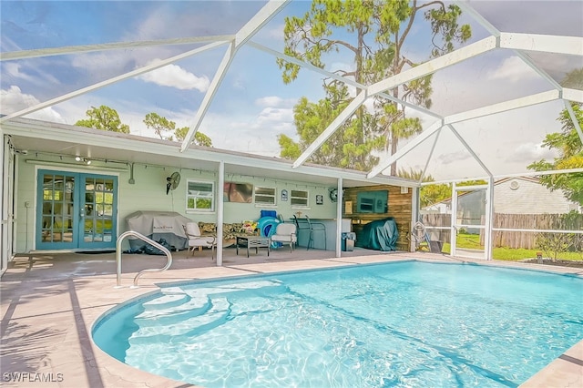 view of swimming pool featuring a shed, a patio area, and a lanai