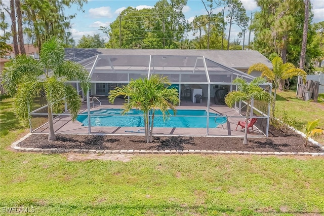 view of swimming pool featuring a yard, a patio area, and a lanai