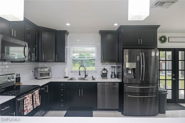 kitchen featuring tasteful backsplash, sink, stainless steel appliances, ornamental molding, and light tile patterned floors