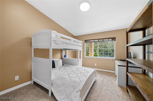 bedroom with light colored carpet and lofted ceiling