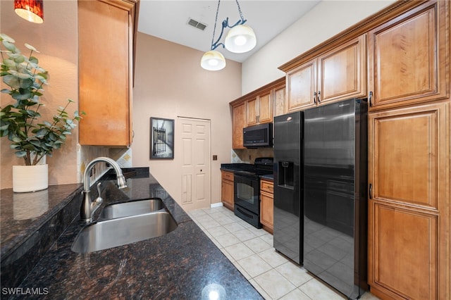 kitchen featuring refrigerator with ice dispenser, decorative light fixtures, black range with electric cooktop, sink, and light tile patterned floors