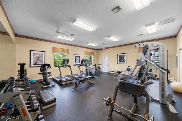 workout area with ceiling fan and a textured ceiling