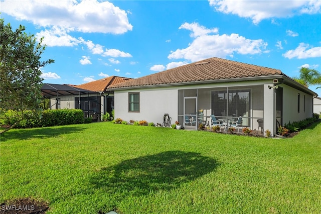 rear view of property with glass enclosure and a lawn