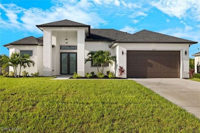 prairie-style home with driveway, french doors, a front yard, a garage, and stucco siding
