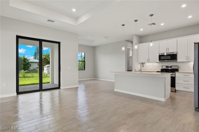 kitchen with light wood-type flooring, a sink, baseboards, and stainless steel range with electric cooktop