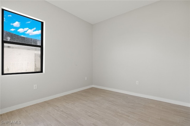 unfurnished room with baseboards and wood finished floors