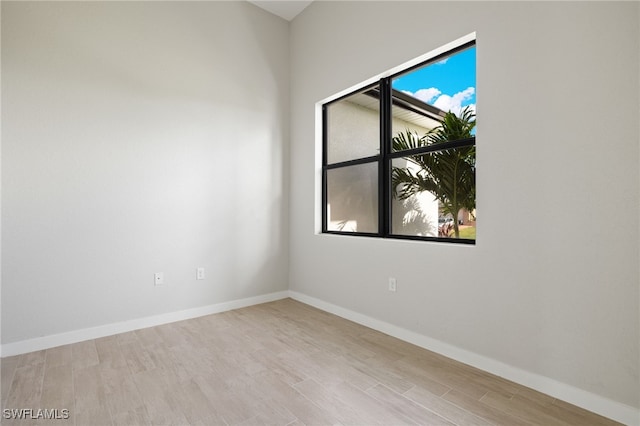 spare room featuring baseboards and wood finished floors