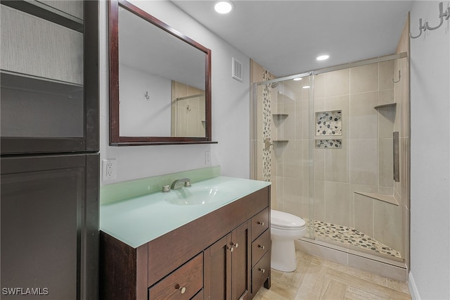 bathroom with walk in shower, vanity, and toilet