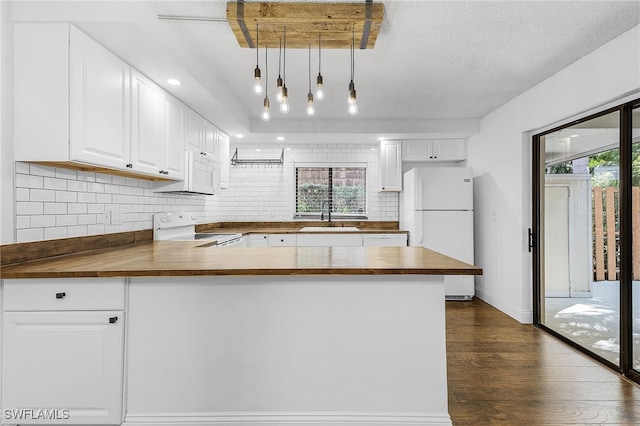 kitchen featuring decorative light fixtures, white appliances, white cabinets, and a wealth of natural light