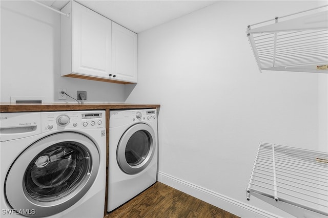 laundry area featuring separate washer and dryer, dark wood-type flooring, and cabinets