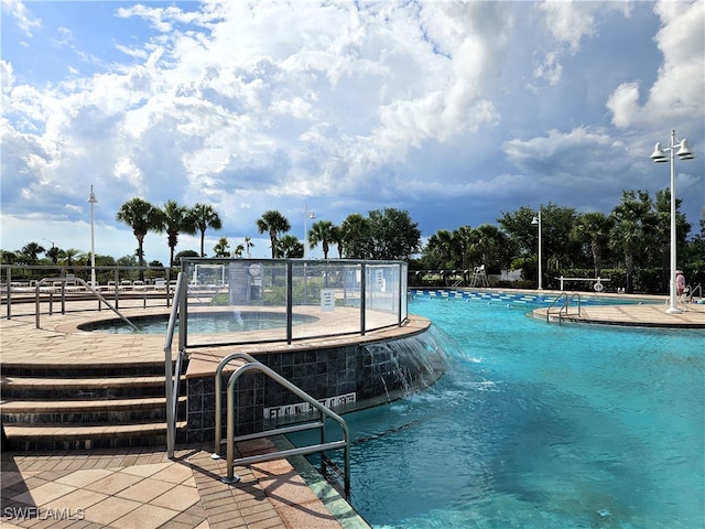 view of pool featuring pool water feature and a patio