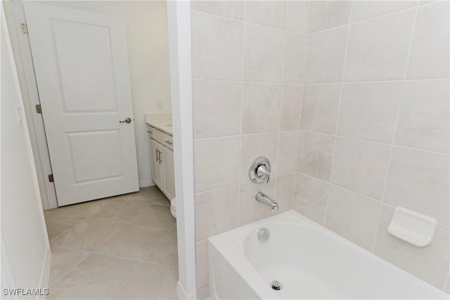 bathroom with tile patterned floors, a bathing tub, and vanity