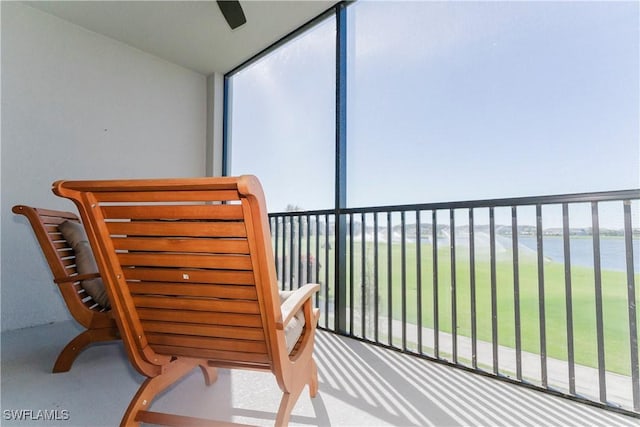 balcony featuring a water view and ceiling fan