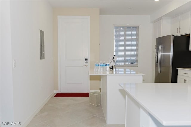 kitchen with white cabinets, light tile patterned floors, stainless steel fridge with ice dispenser, and electric panel