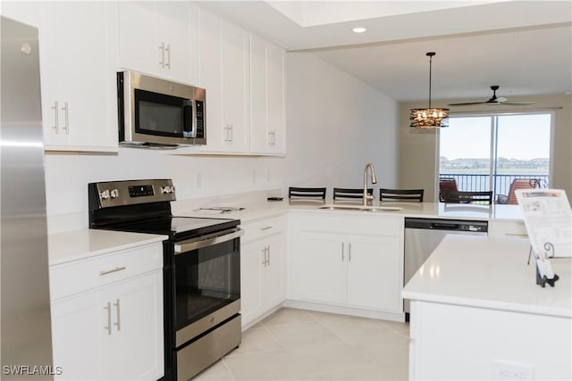 kitchen with hanging light fixtures, kitchen peninsula, sink, and appliances with stainless steel finishes