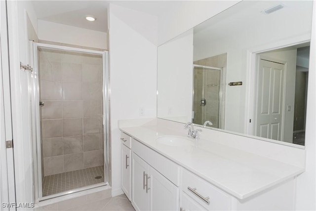 bathroom featuring tile patterned flooring, vanity, and a shower with door