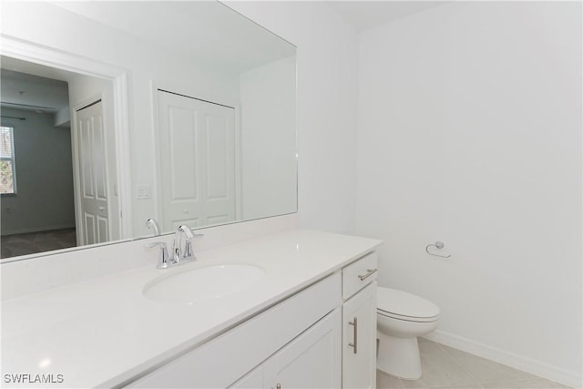 bathroom with tile patterned flooring, vanity, and toilet