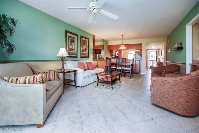 living area with light tile patterned floors and a ceiling fan