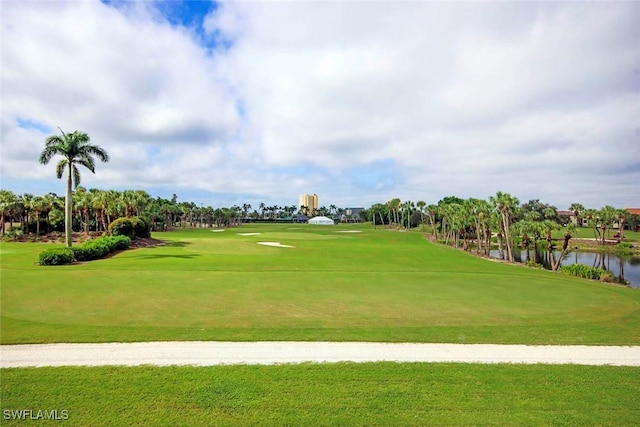 surrounding community featuring a lawn, golf course view, and a water view