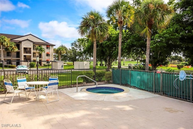 view of pool featuring a community hot tub, a patio area, and fence