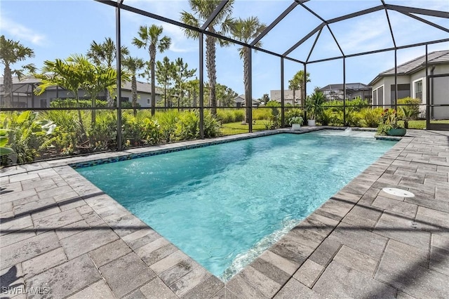 view of swimming pool with glass enclosure and a patio area