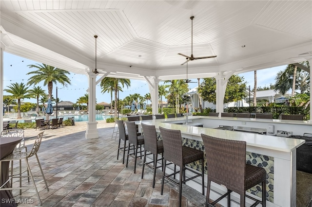 view of patio / terrace with an outdoor bar and ceiling fan