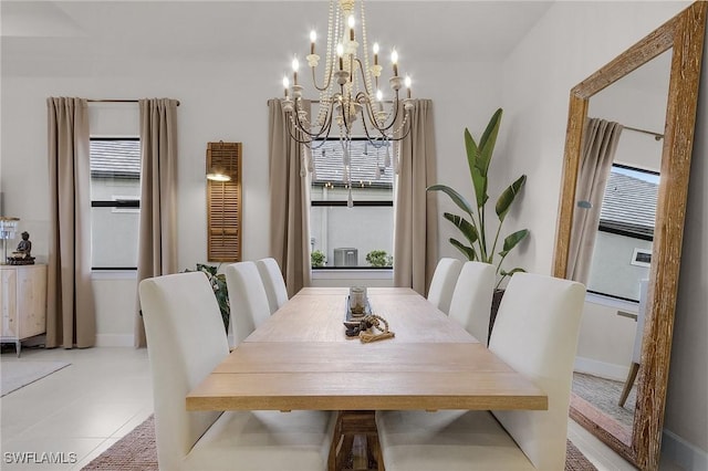 tiled dining room with a chandelier