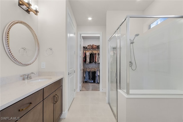 bathroom featuring tile patterned flooring, vanity, and an enclosed shower