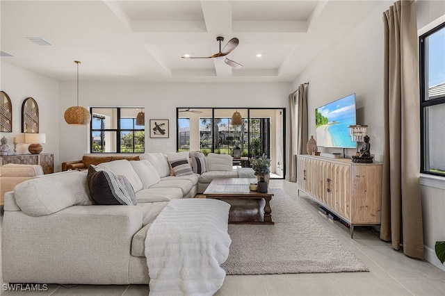 tiled living room with coffered ceiling, a wealth of natural light, and a high ceiling