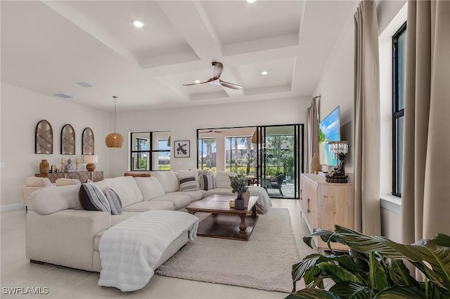 living room featuring coffered ceiling, ceiling fan, beamed ceiling, and a healthy amount of sunlight