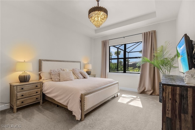 bedroom featuring carpet floors, an inviting chandelier, and a tray ceiling