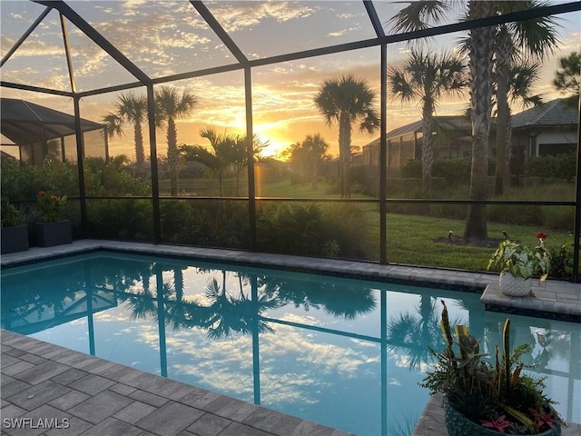 pool at dusk featuring glass enclosure