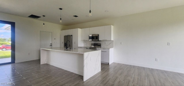 kitchen featuring light hardwood / wood-style flooring, white cabinets, appliances with stainless steel finishes, and decorative light fixtures